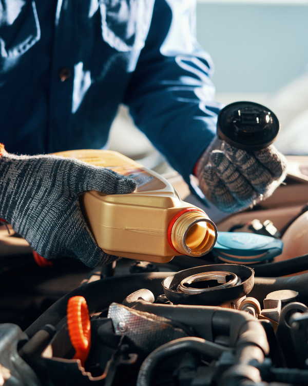 Mecânico abastecendo o motor do carro com óleo novo de alta qualidade.